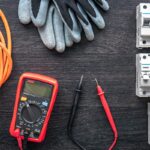 Flat lay composition with electrical tools on wooden background.