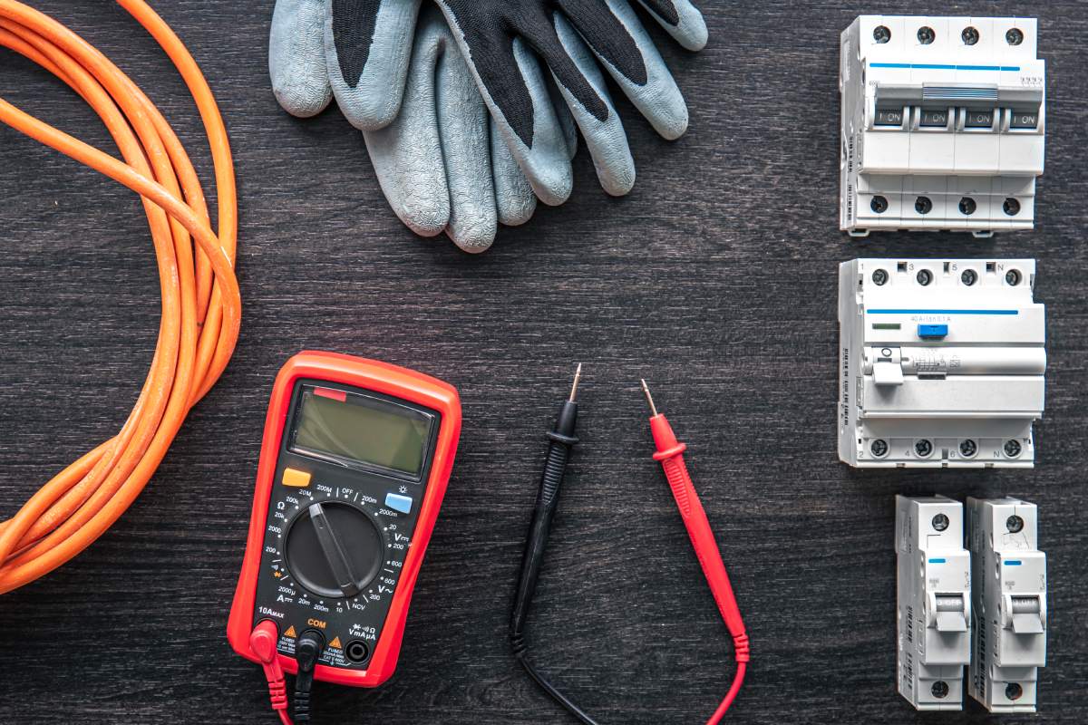 Flat lay composition with electrical tools on wooden background.