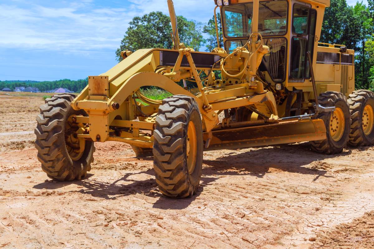 Heavy an earthmoving construction grader tractor with working at construction site