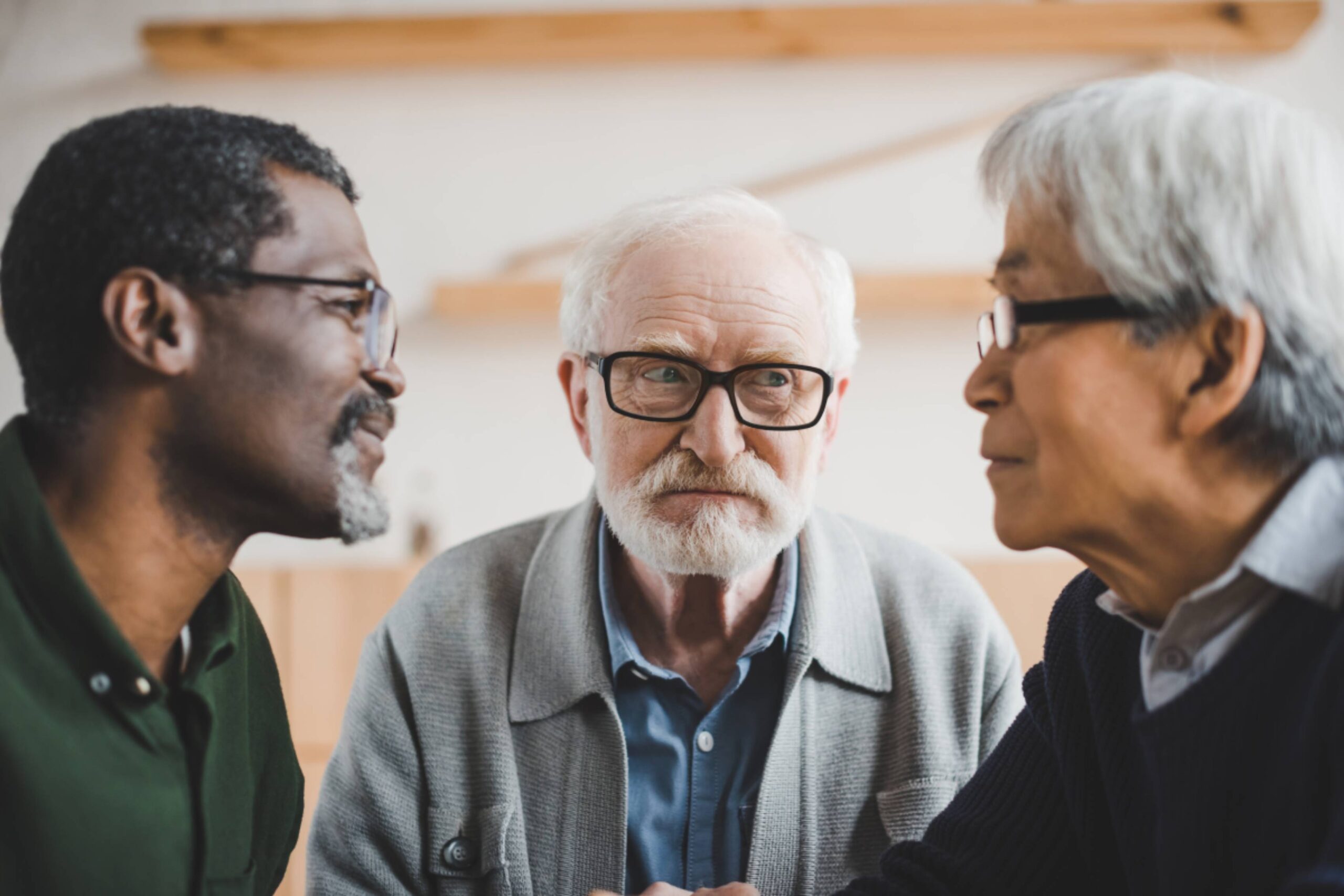 group of focused multiethnic senior friends playing staring contest